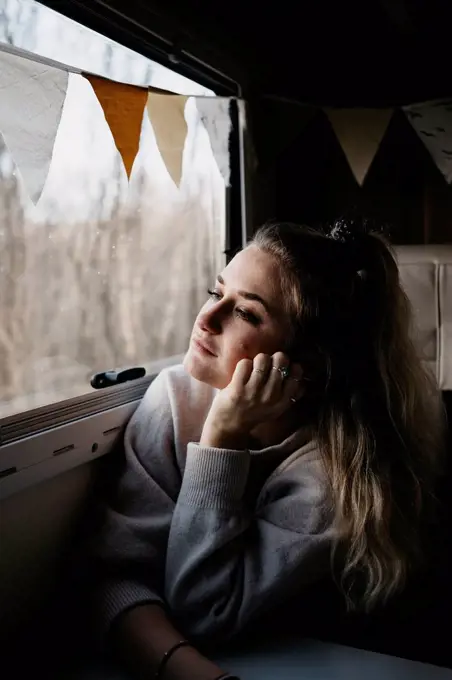 Pensive young woman looking out of car window