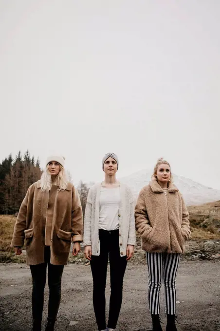 UK, Scotland, three young women standing on a path in rural landscape