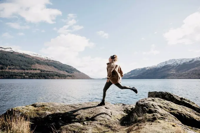 UK, Scotland, young woman running at Loch Lomond