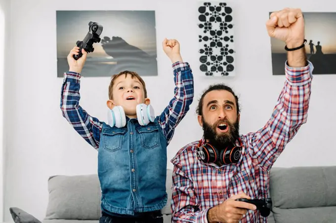 Portrait of father and son playing computer game at home