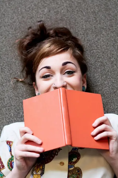 Female student reading book in a public library