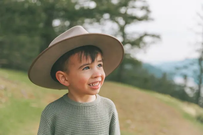 Portrait of a little boy, wearing his mother's hat