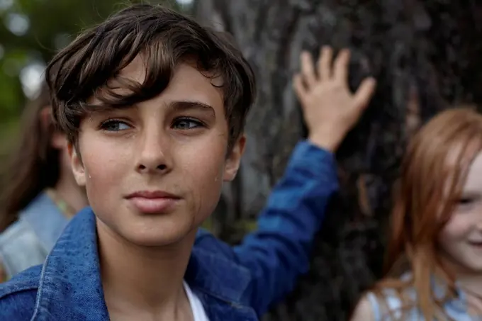 Portrait of boy with friends at a tree