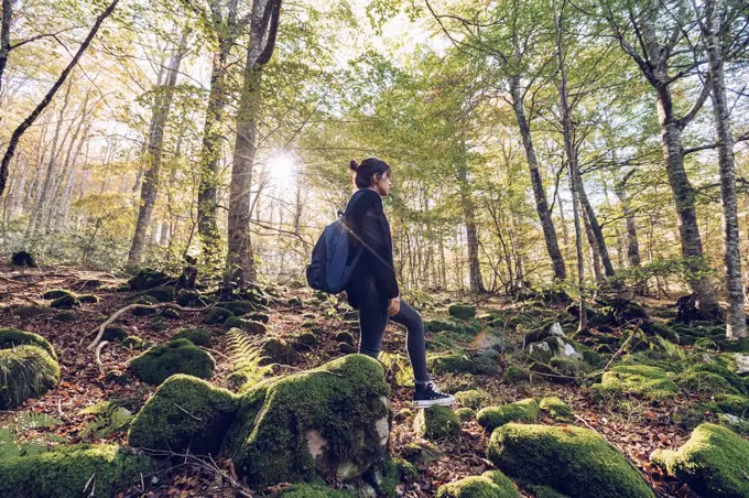 Spain, Navarra, Irati Forest, young woman standing in lush forest