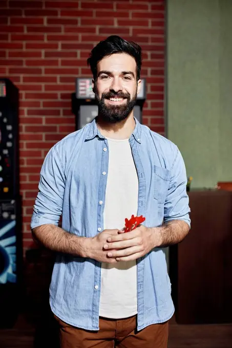 Portrait of smiling man holding darts