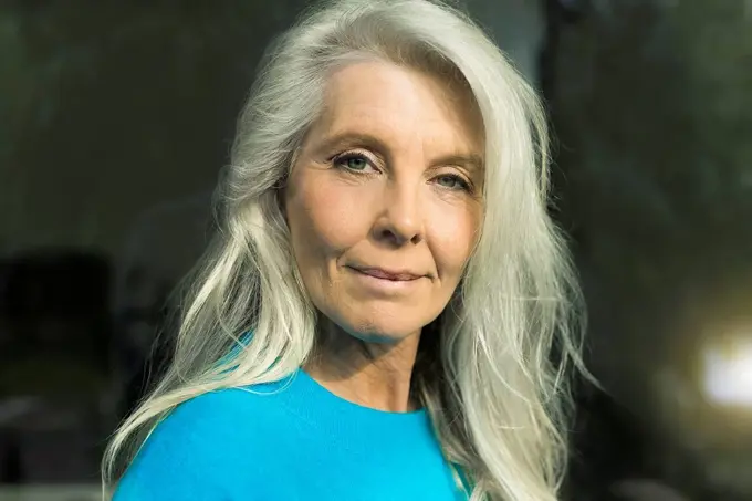 Portrait of content mature woman wearing blue pullover