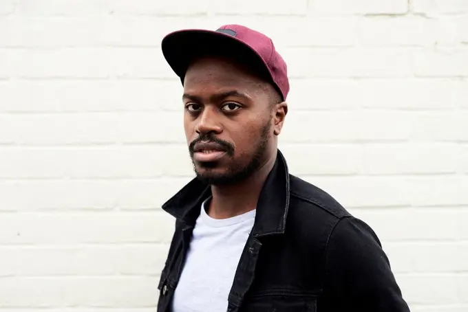 Portrait of mid adult man wearing denim jacket and basecap