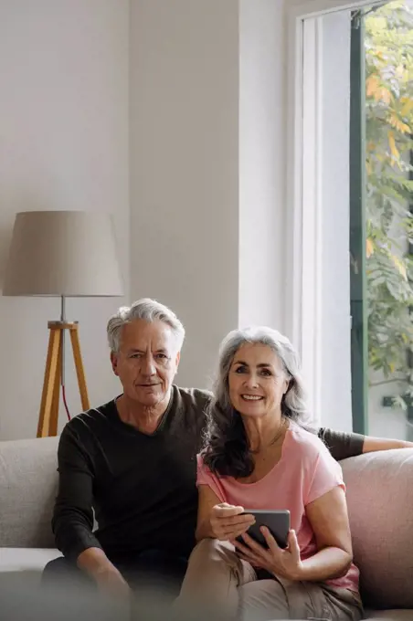 Portrait of senior couple relaxing on couch at home