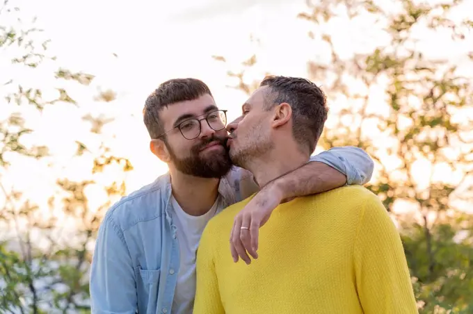 Affectionate gay couple outdoors at sunset