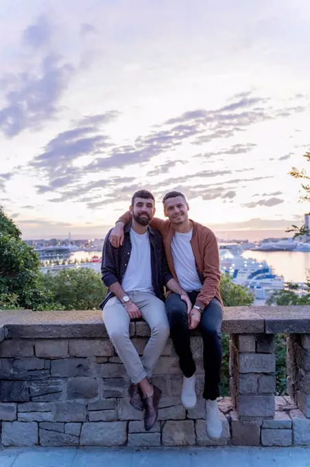 Portrait of gay couple on lookout above the city with view to the port, Barcelona, Spain