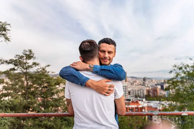 Portrait of happy man hugging his boyfriend, Barcelona, Spain