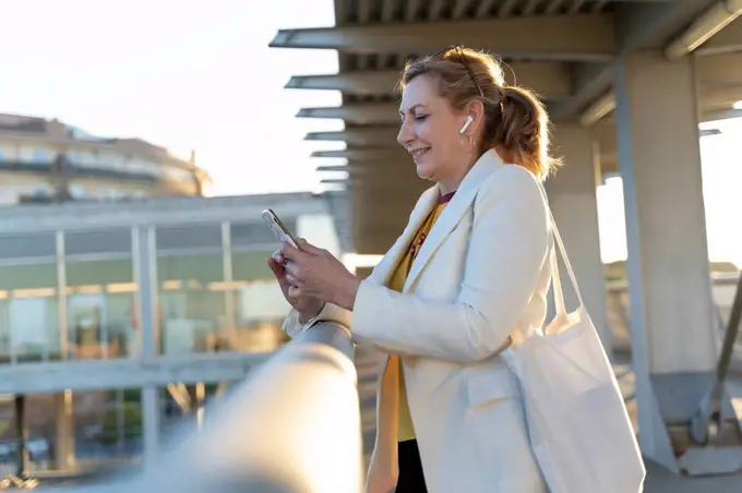 Senior businesswoman commuting in the city, using mobile phone