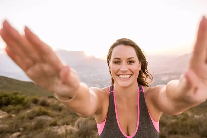 Portrait of happy Plus-Size-Model doing sports in the countryside at sunset