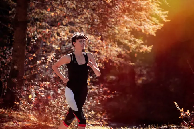 Woman jogging in autumn forest