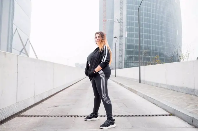 Plus size sportive young woman posing in the city