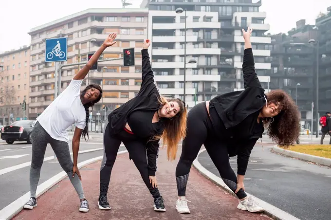 Three sportive young women training in the city