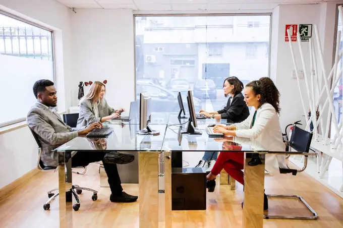 Colleagues working on computers in office