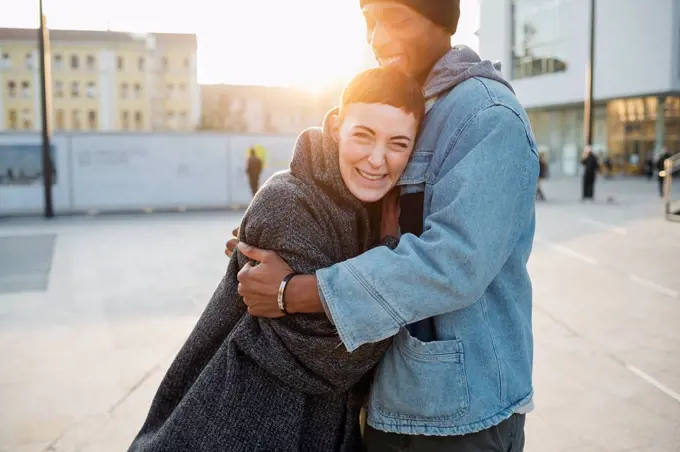 Happy young couple in the city at sunset