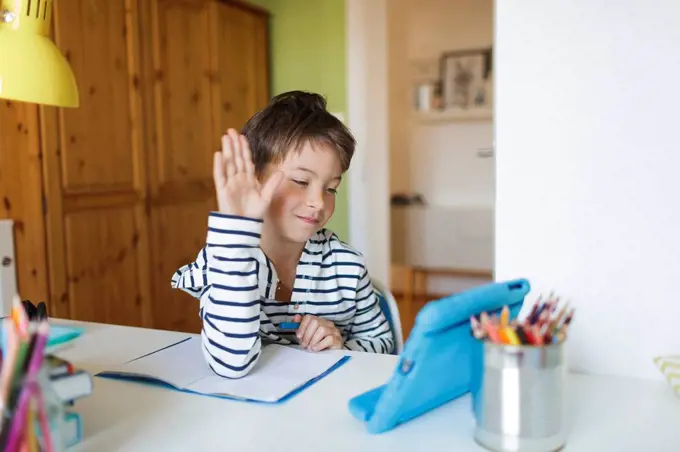 Boy doing homeschooling and using tablet at home