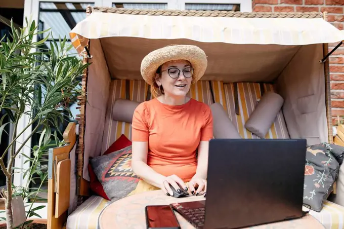 Portrait of mature woman working on laptop on terrace