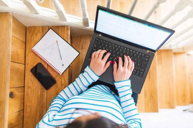 Woman using laptop, notebook and smartphone from above