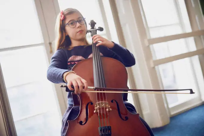 Girl playing cello during a lesson