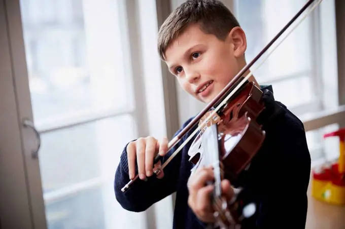 Boy playing violin during a lesson