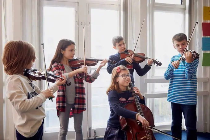 Group of children playing violin during a lesson