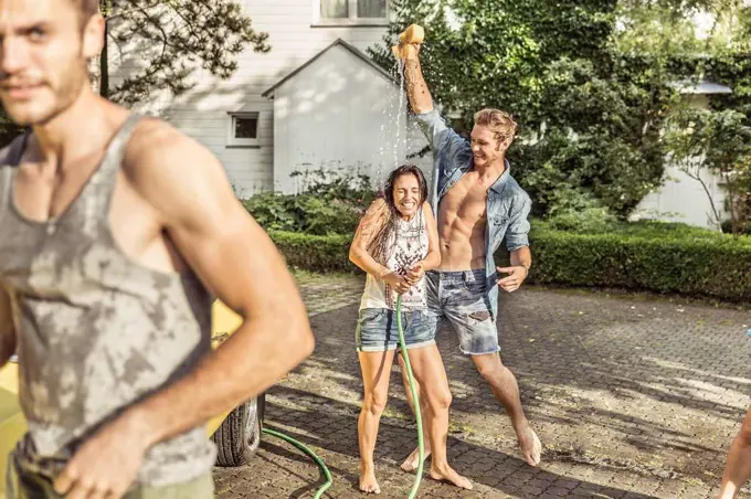 Friends washing car together having fun