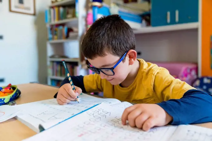 Elementary student learning while sitting at desk during homeschooling