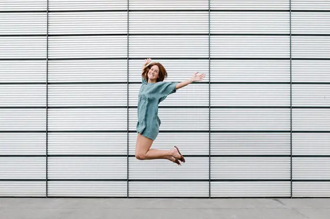 Happy redheaded woman jumping