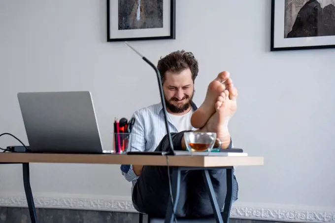 Man sitting at desk, feet up