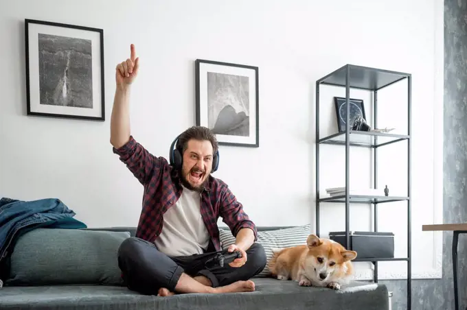 Man sitting on couch and playing video game