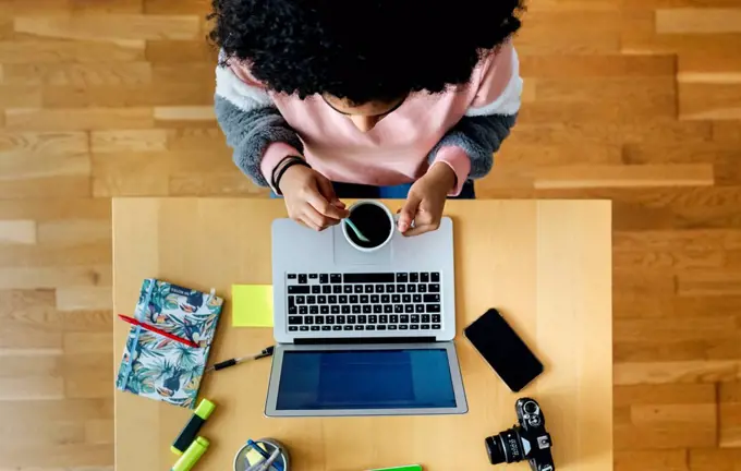 Top view of young woman working from home using laptop