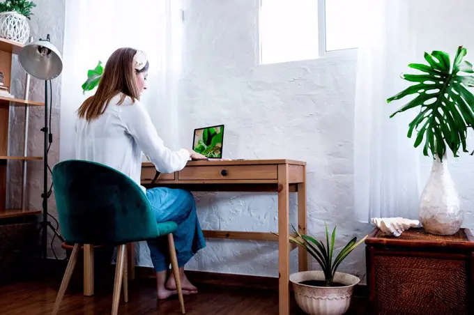 Female photographer processing pictures at home