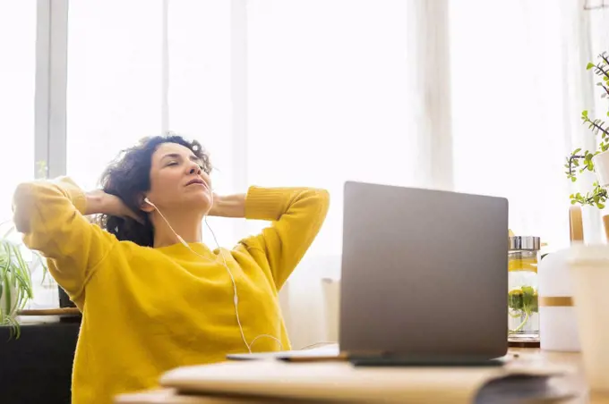 Woman having a break from working at desk in home office