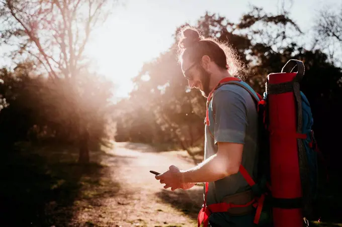 Bearded man with smartphone on a hiking trip