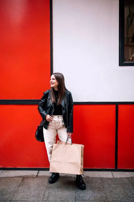 Happy young woman with shopping bags in the city