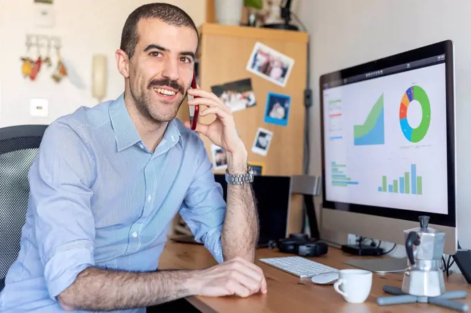 Man working from home, talking on the phone