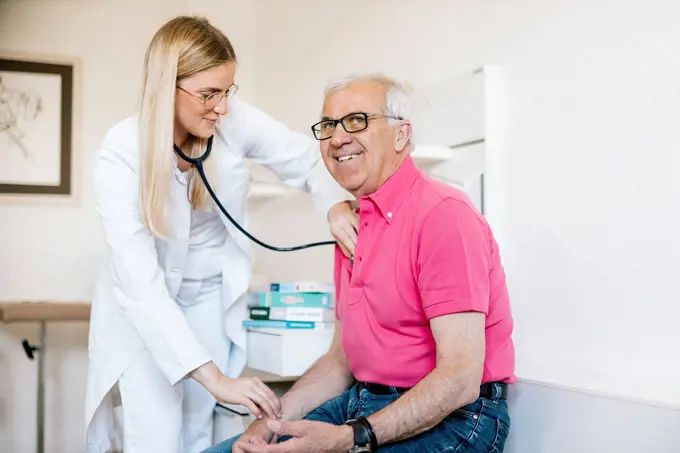 Female doctor examining senior patient in medical clinic