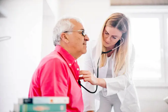 Female doctor examining senior patient in medical clinic