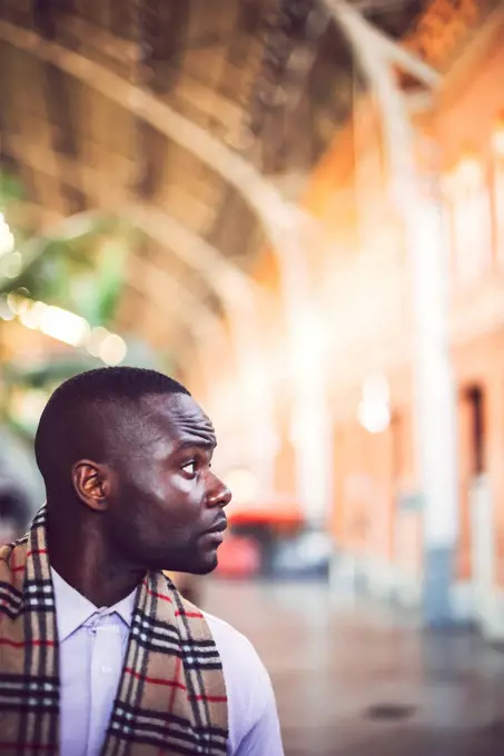 Serious thoughtful businessman looking away while standing at station