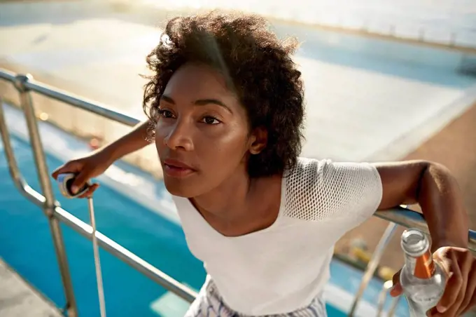 Young woman on highboard of swimming pool