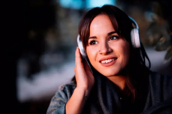 Attractive woman listening to music through headphone in forest