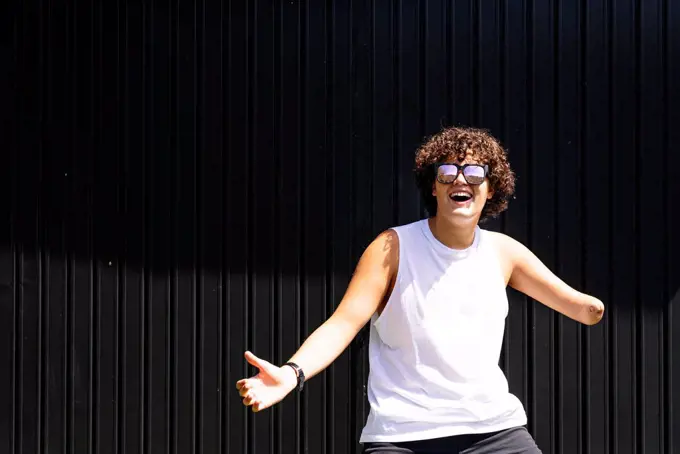 Happy amputee boy dancing against shutter