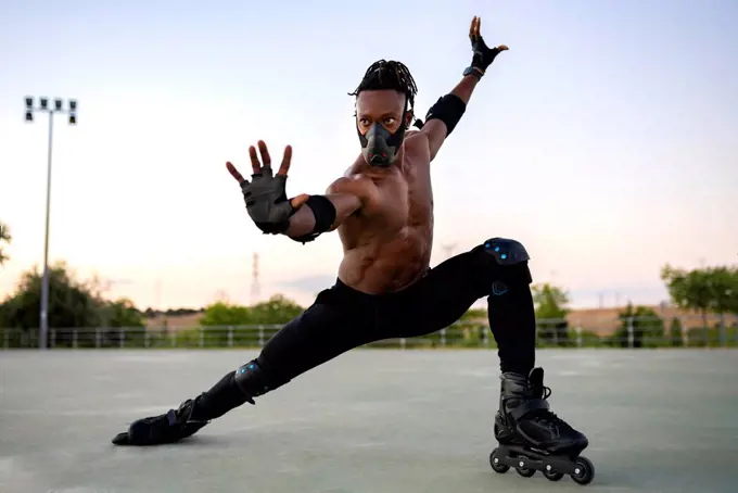 Man wearing protective face mask stretching while standing on ground