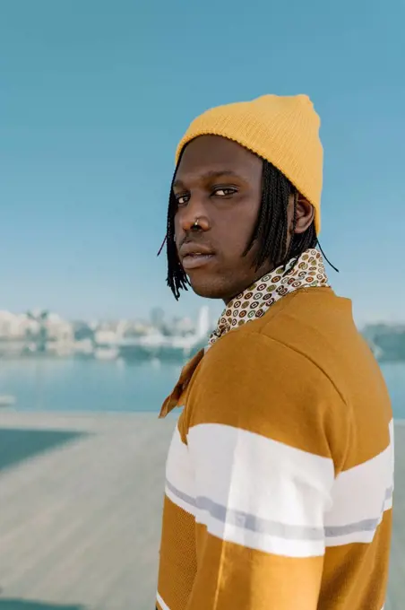 Man in yellow knit hat against glass wall