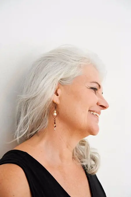 Smiling woman looking away against white background