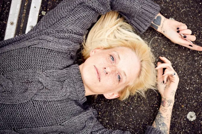 Young woman lying down at parking lot