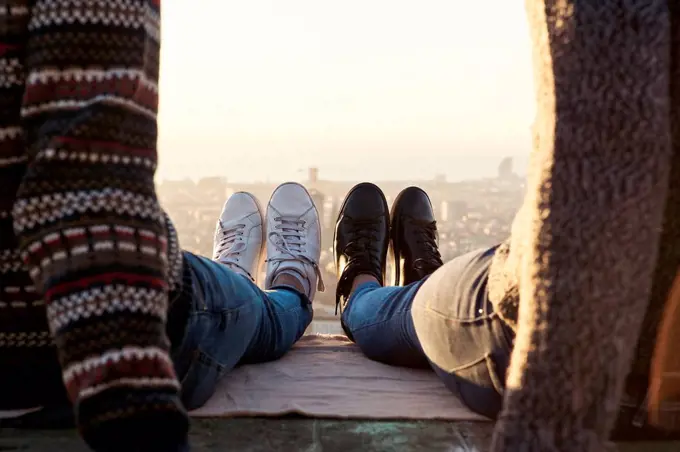 Legs of gay couple wearing shoes sitting on observation point, Bunkers del Carmel, Barcelona, Spain